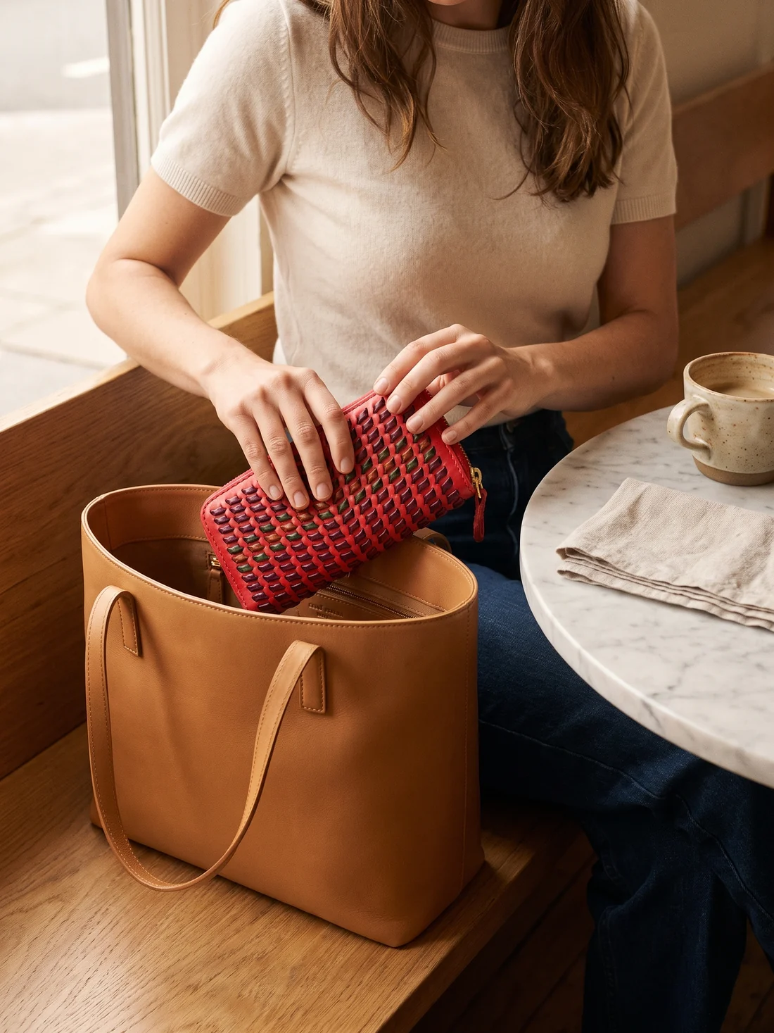 GÖN Handmade Woven Zip Wallet worn — carried in Red Multi, from the campaign